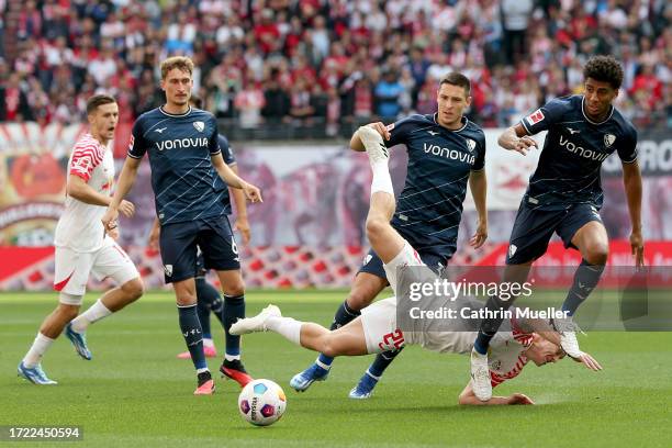 Keven Schlotterbeck and Bernardo of VfL Bochum clash with Xaver Schlager of RB Leipzig during the Bundesliga match between RB Leipzig and VfL Bochum...