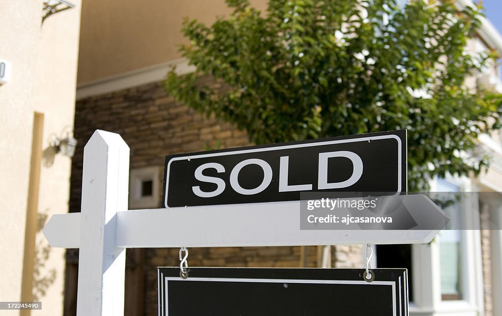 A real estate sign saying sold