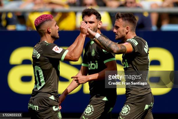 Aleix Garcia of Girona FC celebrates with team mate Yan Couto after scoring their sides first goal during the LaLiga EA Sports match between Cadiz CF...