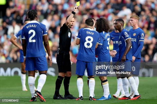 Match Referee Stuart Attwell shows a yellow card to Enzo Fernandez of Chelsea during the Premier League match between Burnley FC and Chelsea FC at...