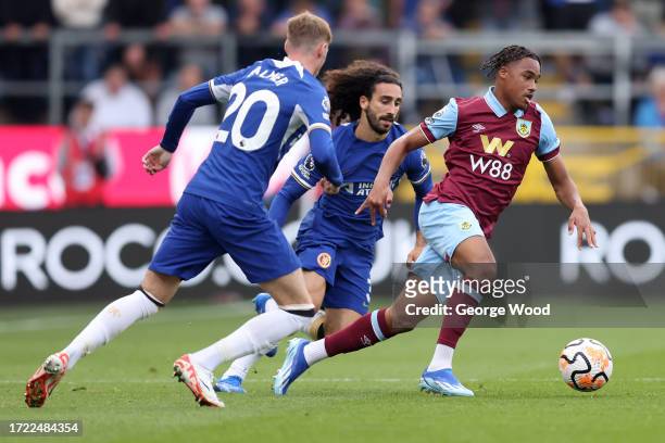 Wilson Odobert of Burnley is challenged by Marc Cucurella and Cole Palmer of Chelsea during the Premier League match between Burnley FC and Chelsea...