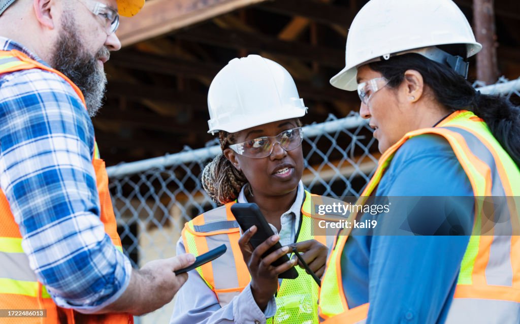 Worker Using Phone Three Construction Workers Meet Using Mobile Phones High-Res Stock ...