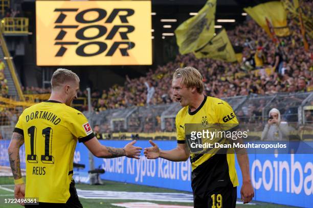 Julian Brandt of Borussia Dortmund celebrates with team mate Marco Reus after scoring their sides third goal during the Bundesliga match between...
