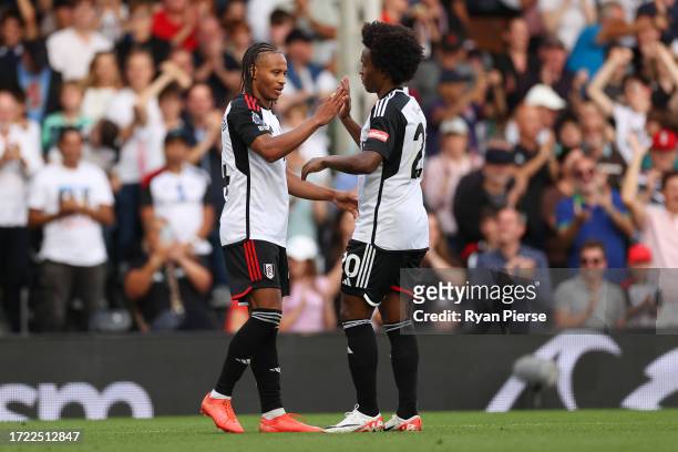 Bobby Reid of Fulham celebrates with teammate Willian after scoring the team's first goal during the Premier League match between Fulham FC and...