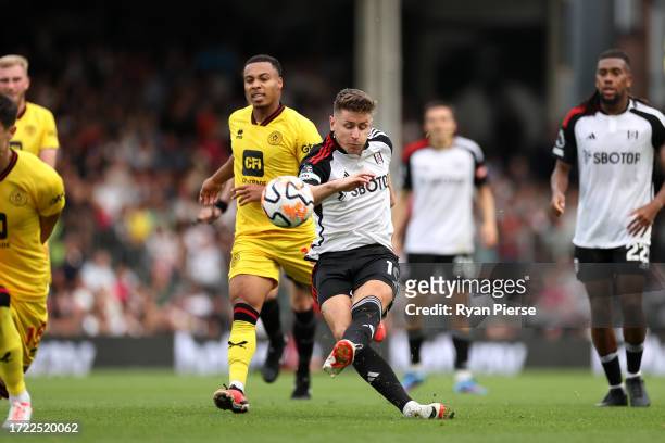 Tom Cairney of Fulham shoots leading to Wes Foderingham of Sheffield United scoring an own goal during the Premier League match between Fulham FC and...