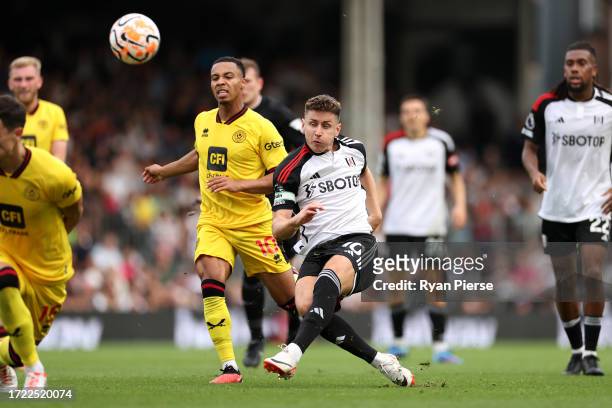 Tom Cairney of Fulham shoots leading to Wes Foderingham of Sheffield United scoring an own goal during the Premier League match between Fulham FC and...