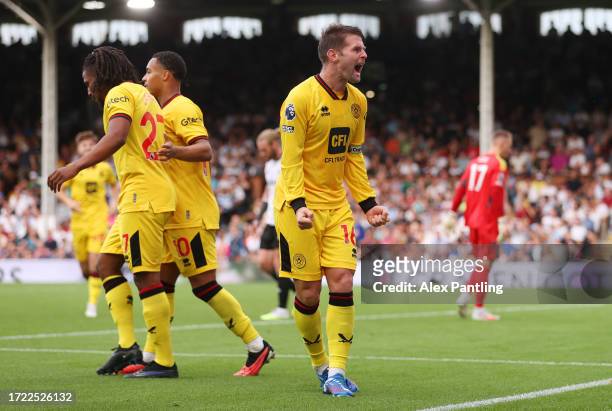 Oliver Norwood of Sheffield United celebrates after Antonee Robinson of Fulham scores an own goal during the Premier League match between Fulham FC...