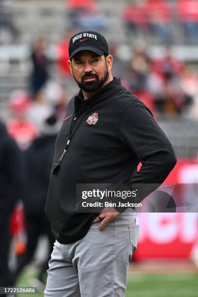 Head Coach Ryan Day of the Ohio State Buckeyes watches warmups prior to a game against the Maryland Terrapins at Ohio Stadium on October 07, 2023 in...