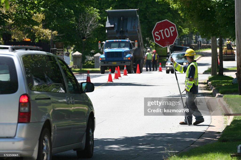 A man controlling traffic with a sign