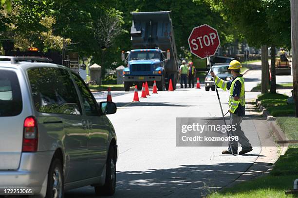 a man controlling traffic with a sign - road construction worker stock pictures, royalty-free photos & images