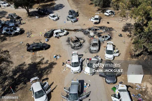 This aerial picture shows abandoned and torched vehicles at the site of the October 7 attack on the Supernova desert music Festival by Palestinian...