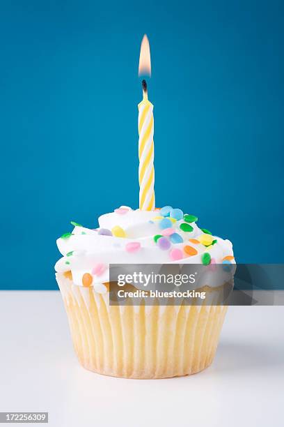 birthday cupcake with white icing and sprinkles and candle - birthday cupcake stock pictures, royalty-free photos & images