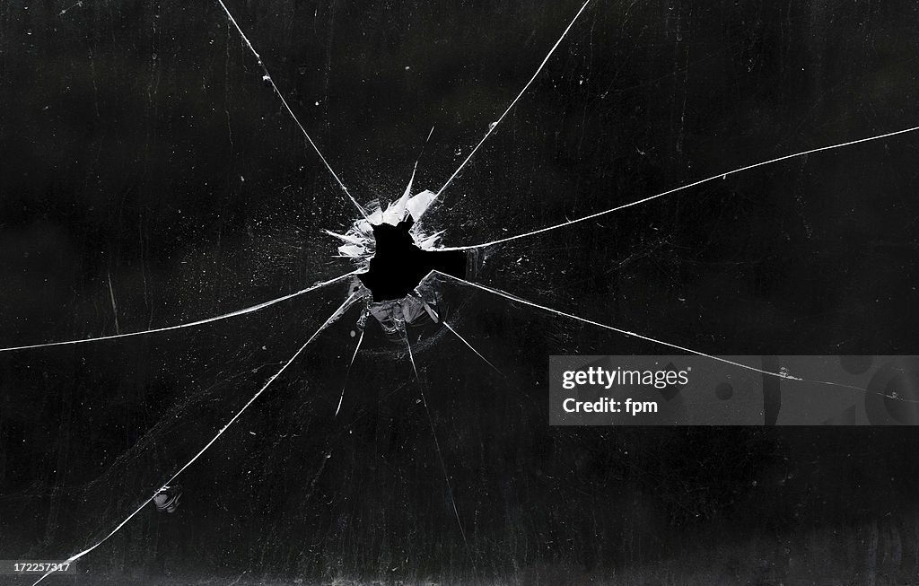 A bullet hole in a glass window