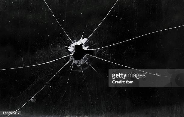 a bullet hole in a glass window - shooting a weapon stock pictures, royalty-free photos & images