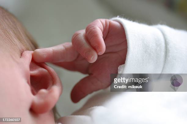 baby ear hand finger listen - luisteren stockfoto's en -beelden