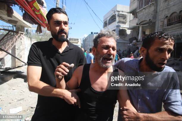 Man cries as civil defense members and residents conduct search and rescue operation amid rubble and destroyed buildings after Israeli airstrikes...