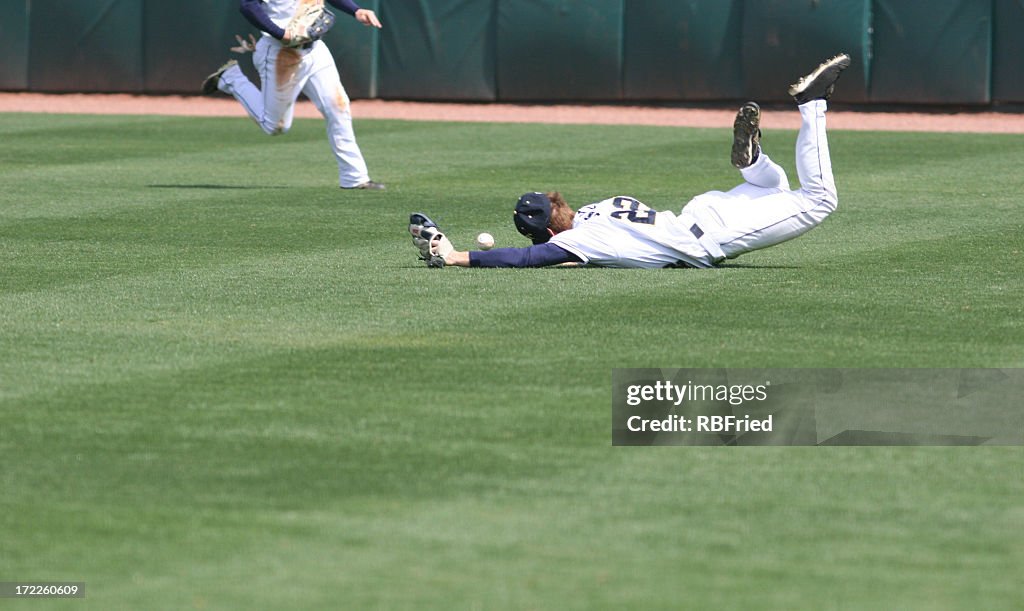 Man diving and missing the catch in baseball