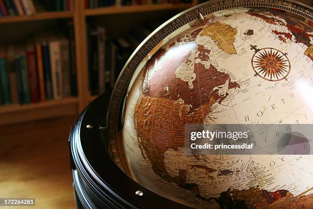 close up of a globe in a library - globe navigational equipment stockfoto's en -beelden