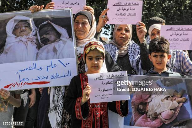 Graphic content / Women and children hold signs in support of the Hamas "al-Aqsa flood" operation and showing pictures of Palestinian child victims,...