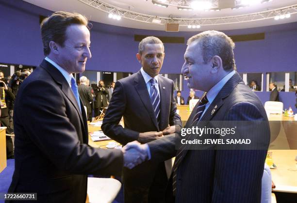 President Barack Obama looks on as British Prime Minister David Cameron shakes hands with Egyptian Prime Minister Essam Sharaf before an expanded...