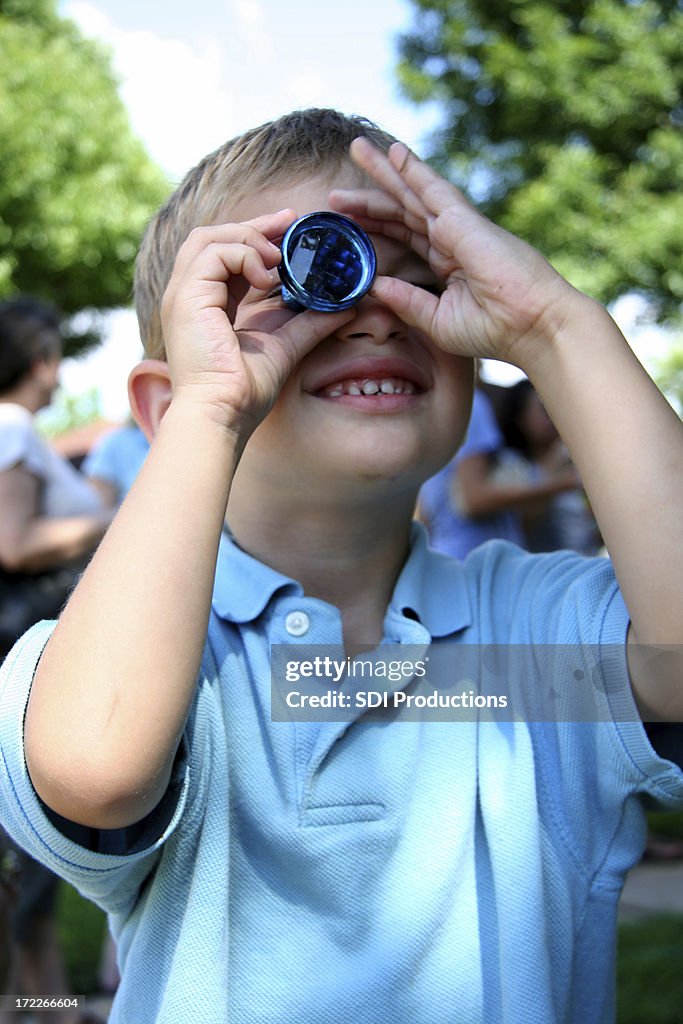 Young Boy Looking Through un juguete Kaleidescope
