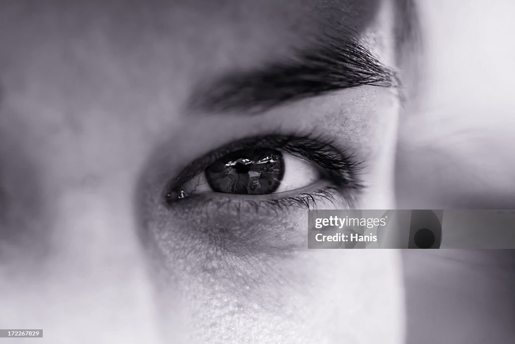 A focus shot of an eye of a man in black and white 