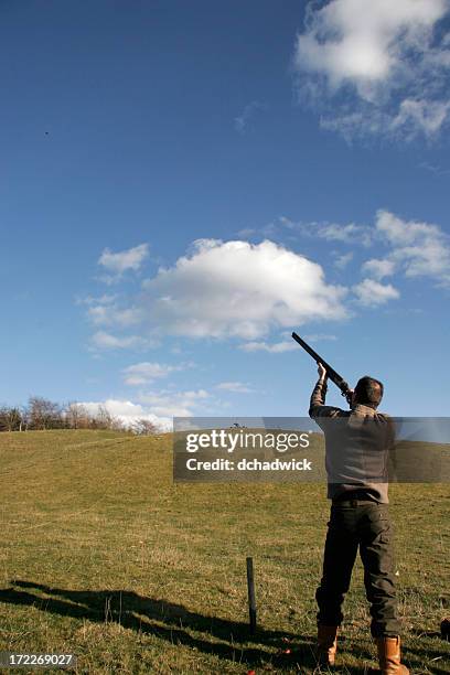 a man aiming and shooting at clay pigeons - skeet shooting stock pictures, royalty-free photos & images