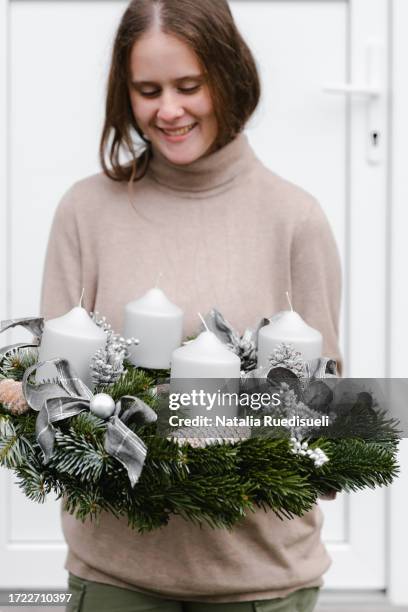 young girl 14-15 years old holding adventskranz with four candles and smiling. - celebrating 15 years stock pictures, royalty-free photos & images