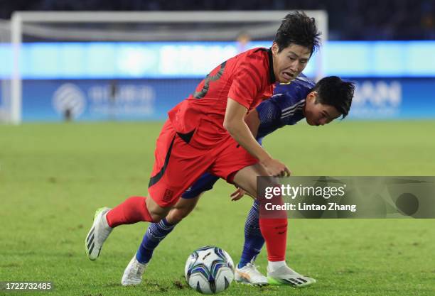 Kang-in Lee of Korea in action competes for the ball with Hayato Okuda of Japan during the 19th Asian Game men's gold medal match between South Korea...