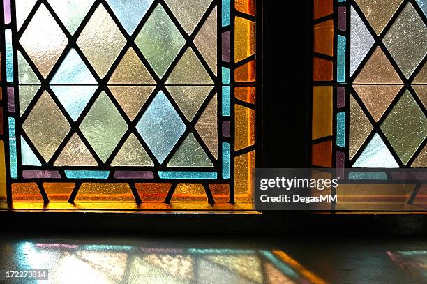 a close up of two stained glass windows - stained glass stockfoto's en -beelden