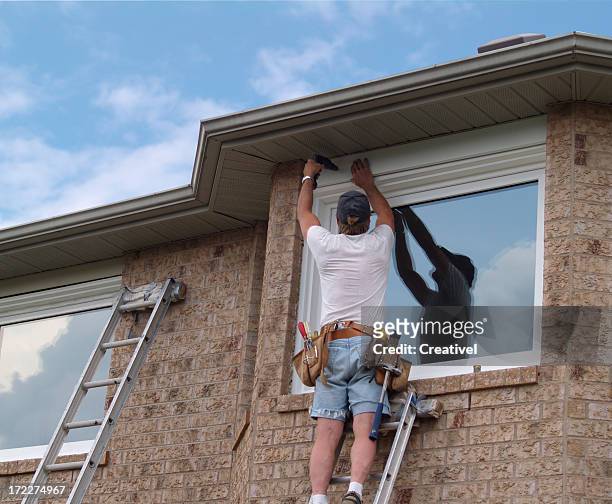 window installation, contractor attaching trims around the newly installed window - laying stock pictures, royalty-free photos & images