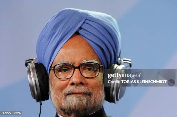 Indian Prime Minister Manmohan Singh listens in as German Chancellor Angela Merkel addresses a joint press conference at the chancellery in Berlin on...