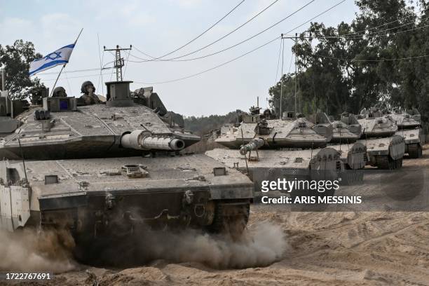 Graphic content / Israeli army Merkava battle tanks deploy along the border with the Gaza Strip in southern Israel on October 13 as battles between...