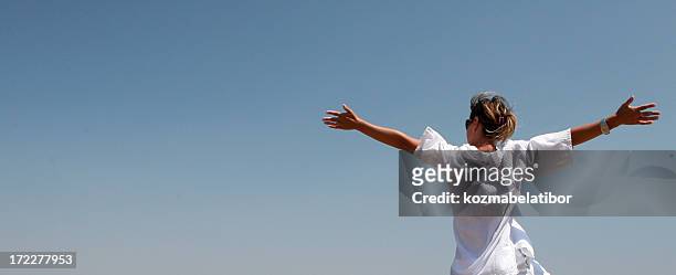 a woman stretching her arms in freedom - nice weather stock pictures, royalty-free photos & images