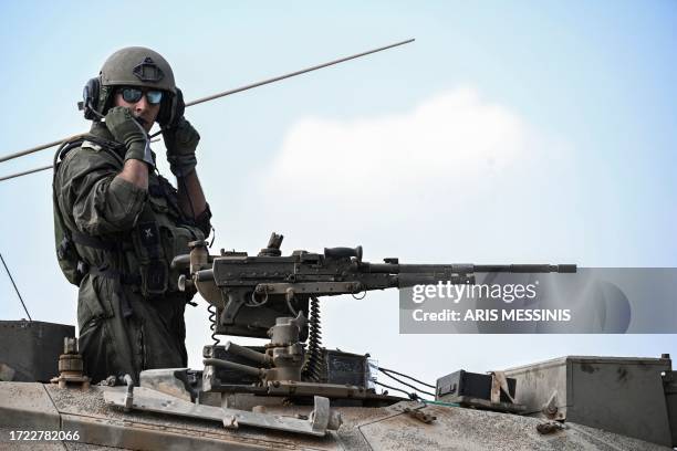 Graphic content / An Israeli soldier stands in a Merkava battle tank as it deploys with other tanks along the border with the Gaza Strip in southern...