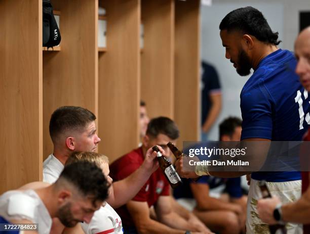 Owen Farrell of England toasts a Asahi beer with Manu Tuilagi in the changing room after the Rugby World Cup France 2023 match between England and...