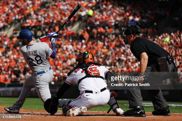 Jonah Heim of the Texas Rangers hits an RBI single during the fourth inning of Game One of the American League Division Series against the Baltimore...