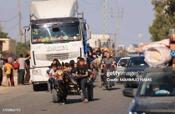 Riding a donkey drawn cart as family along with hundreds of other Palestinian carrying their belongings flee following the Israeli army's warning to...