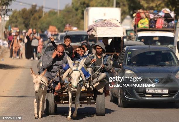 Riding a donkey drawn cart as family along with hundreds of other Palestinian carrying their belongings flee following the Israeli army's warning to...