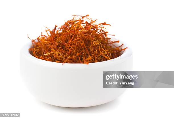 saffron spice in bowl, red spanish seasoning isolated on white - saffron stock pictures, royalty-free photos & images