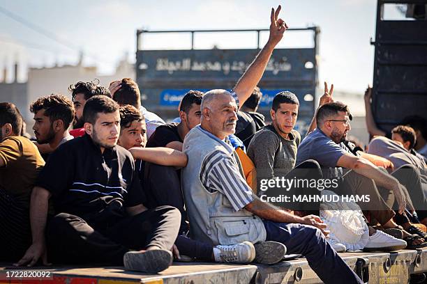 Palestinian man shows the V-sign for victory as he and other leave following the Israeli army's warning to leave their homes and move south before an...