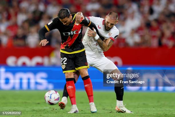 Raul de Tomas of Rayo Vallecano battles for possession with Nemanja Gudelj of Sevilla FC during the LaLiga EA Sports match between Sevilla FC and...