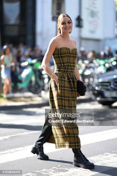 Olivia Palermo wears an off shoulder green khaki long thick checkered wool bustier dress with pockets, black leather boots, outside Zimmermann,...