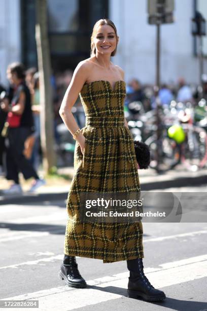 Olivia Palermo wears an off shoulder green khaki long thick checkered wool bustier dress with pockets, black leather boots, outside Zimmermann,...