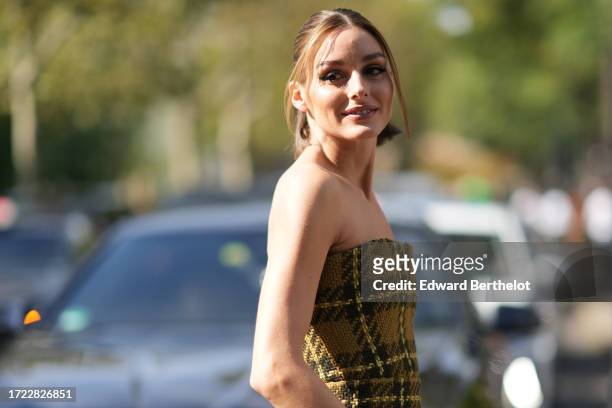 Olivia Palermo wears an off shoulder green khaki long thick checkered wool bustier dress with pockets, outside Zimmermann, during the Womenswear...