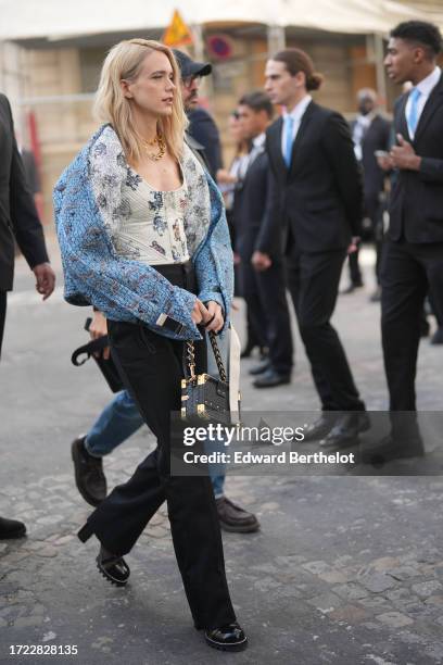 Stacy Martin wears a a blue jacket, a low-neck top, black pants, outside Louis Vuitton , during the Womenswear Spring/Summer 2024 as part of Paris...