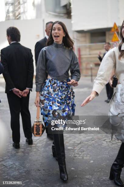 Danielle Haim wears a gray turtleneck top, a sequined skirt, a brown leather monogram Vuitton bag, knee high black leather boots, outside Louis...