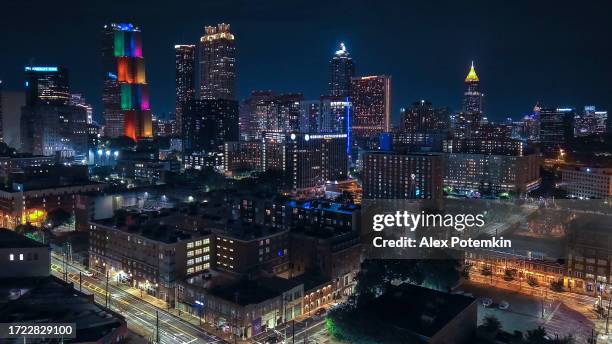 night illuminated downtown district of capital city atlanta, georgia. office skyscrapers light the streets. aerial view - atlanta aerial stock pictures, royalty-free photos & images