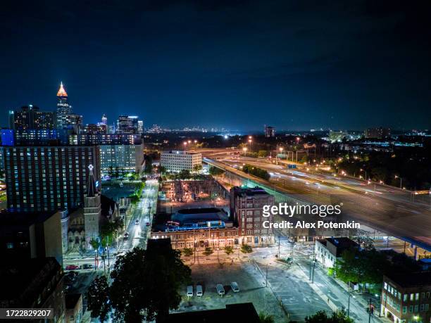 night starlit cityscape of atlanta – capital of georgia. wealthy apartment complexes and hotels line the highway in illuminated city - atlanta skyline car stock pictures, royalty-free photos & images