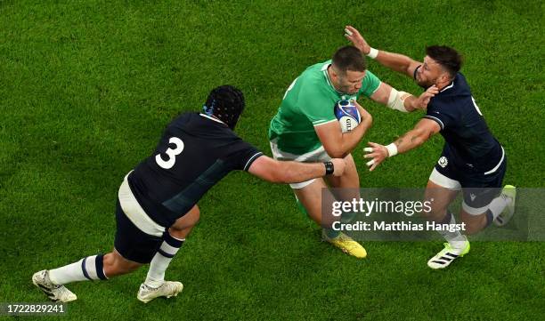 Stuart McCloskey of Ireland is challenged by Zander Fagerson and Ali Price of Scotland during the Rugby World Cup France 2023 match between Ireland...